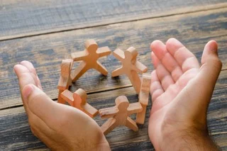 Mains protégeant des figurines, symbole de la protection d’une équipe
